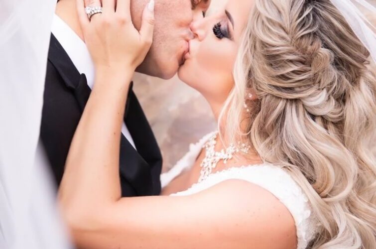 Bride Kissing Groom with Luxurious Makeup by Kristy's Artistry Design Team