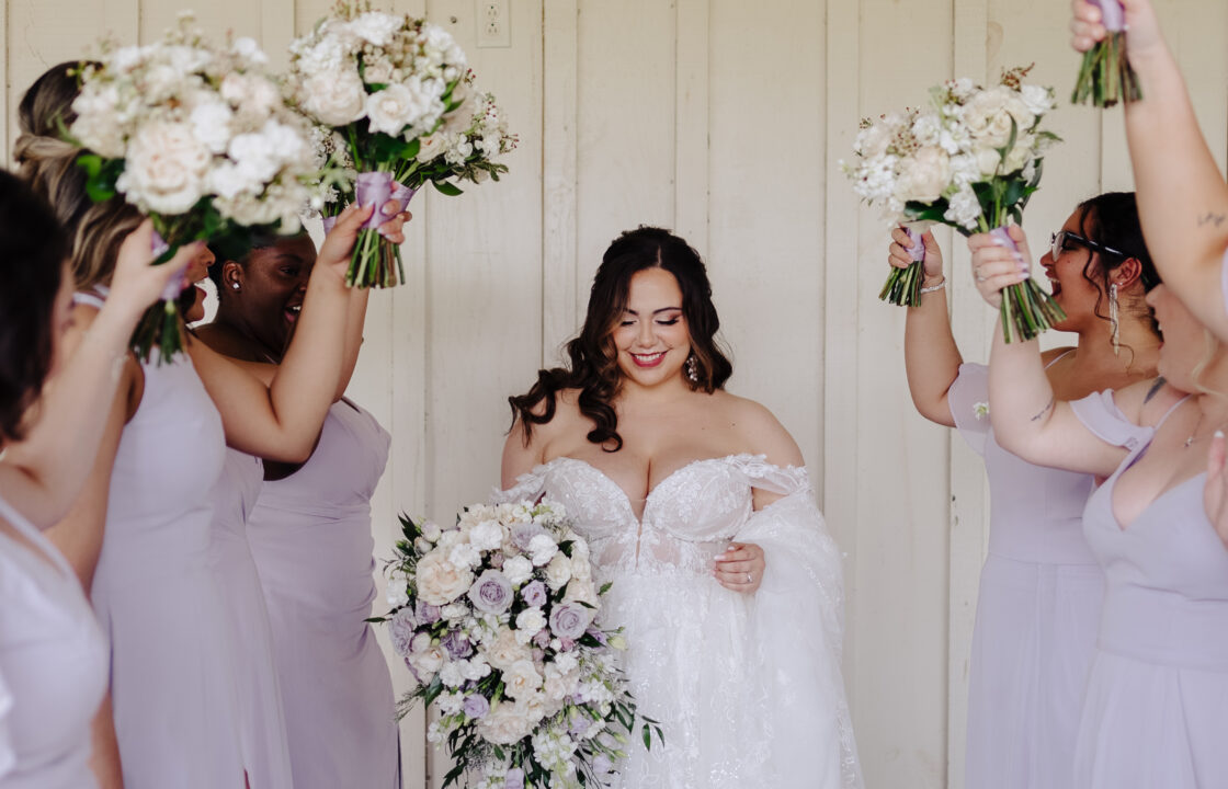 Dancing joy: Bride twirls as bridesmaids cheer, showcasing amazing hair styled by Kristy's Artistry Design Team.