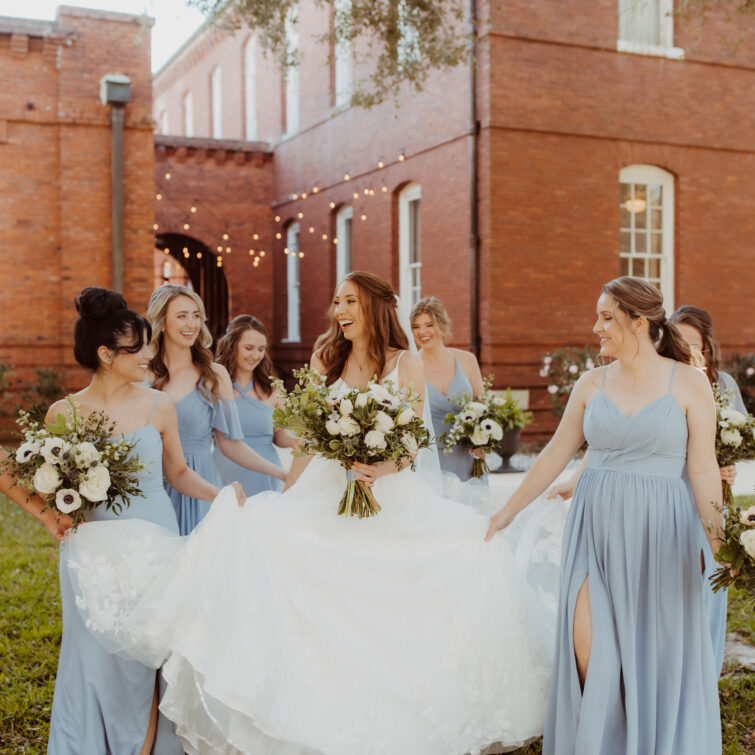 Smiling Bride with Six Bridesmaids Holding Flowers, Hair and Makeup by Kristy's Artistry Design Team