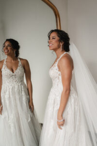 Bride Smiling in Mirror: Showcasing Natural Beauty and Top-Notch Work by Kristy's Artistry Design Team