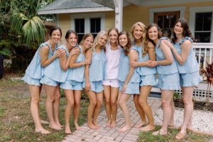 Cheerful bride and bridesmaids in pajamas, showcasing flawless hair and makeup by Kristy's Artistry Design Team in this pre-wedding group photo.