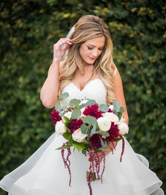 Bride holding bouquet with hair and makeup by Kristy's Artistry Design Team