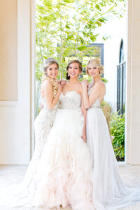 Picture-Perfect Moments: Bride and Bridesmaids Radiate Beauty with Kristy's Artistry Design Team. Image of a bride and two bridesmaids posing for a perfect photo after getting hair and makeup done by Kristy's Artistry Design Team.