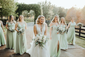 A Glamorous Exit: Bride and Bridesmaids Radiate Beauty with Hair and Makeup by Kristy's Artistry Design Team Bride and 6 bridesmaids leaving heart-shaped garden, holding flowers, looking amazing with hair and makeup by Kristy's Artistry Design Team