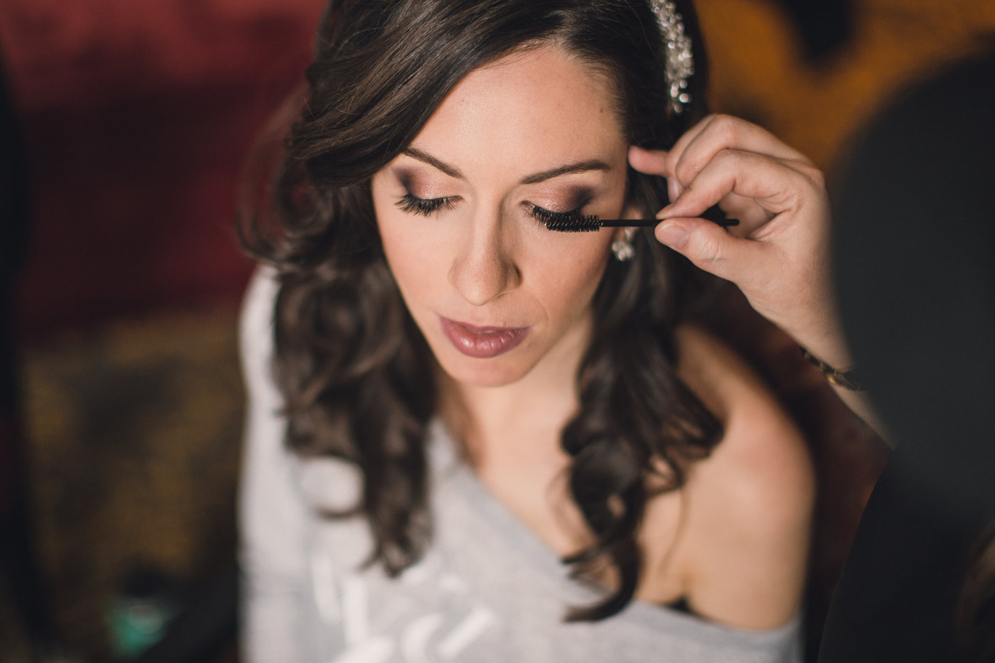 Professional makeup artist from Kristy's Artistry Design Team applying mascara to a bride for the finishing touches before her wedding in Orlando, FL.