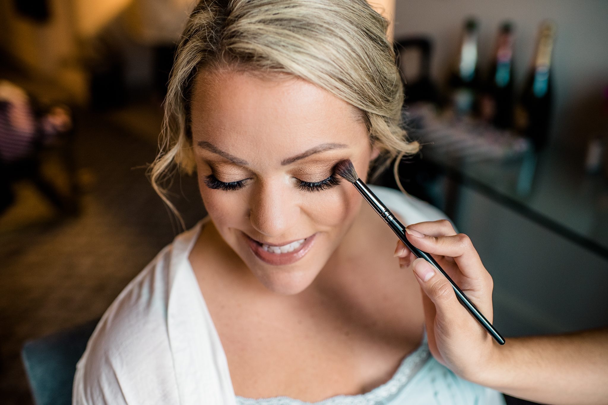 Professional makeup artist from Kristy's Artistry Design Team applying eye color to a bride on her wedding day in Orlando.