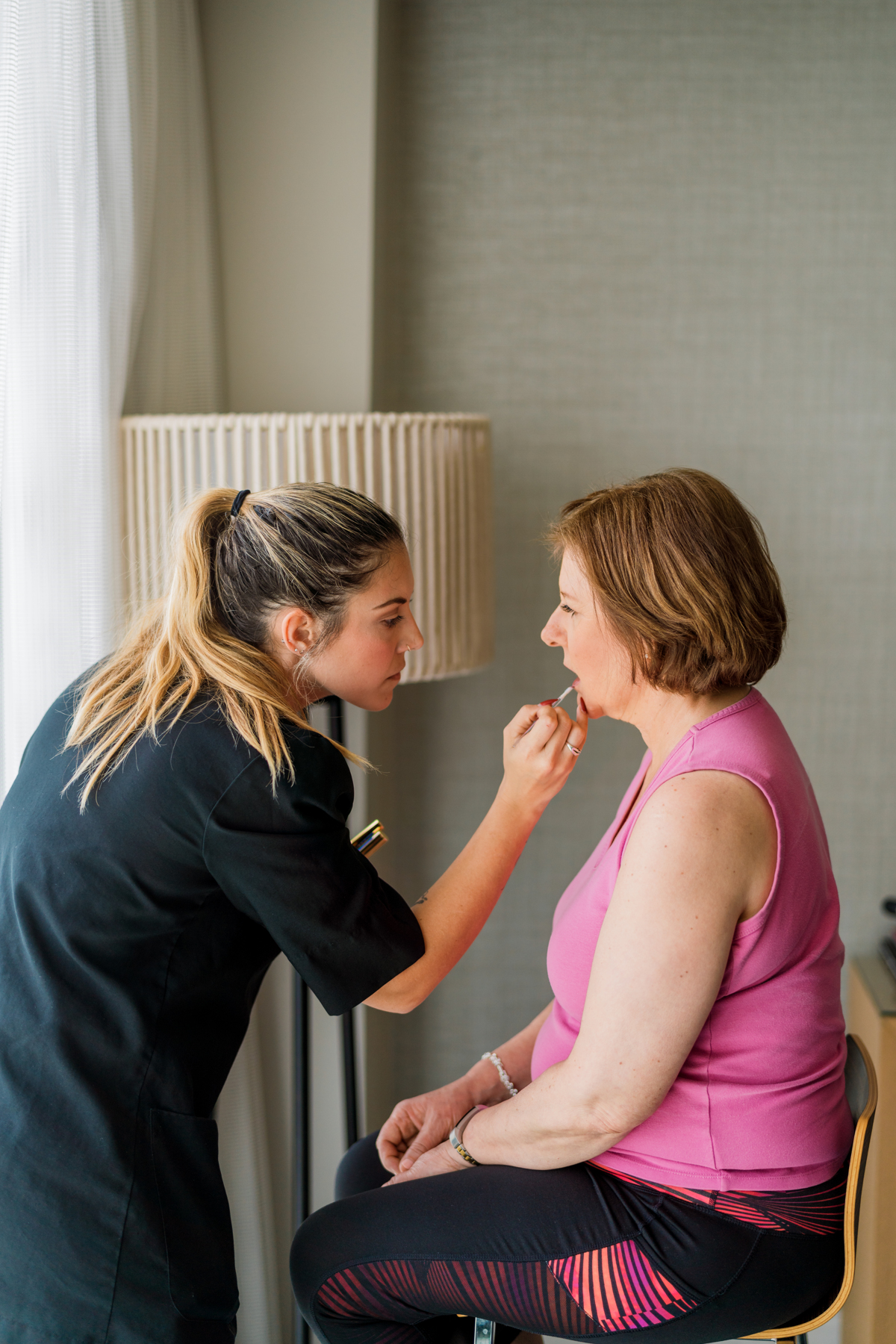 Kristy's Artistry Design Team artist applying lip balm to a bride pre-wedding.