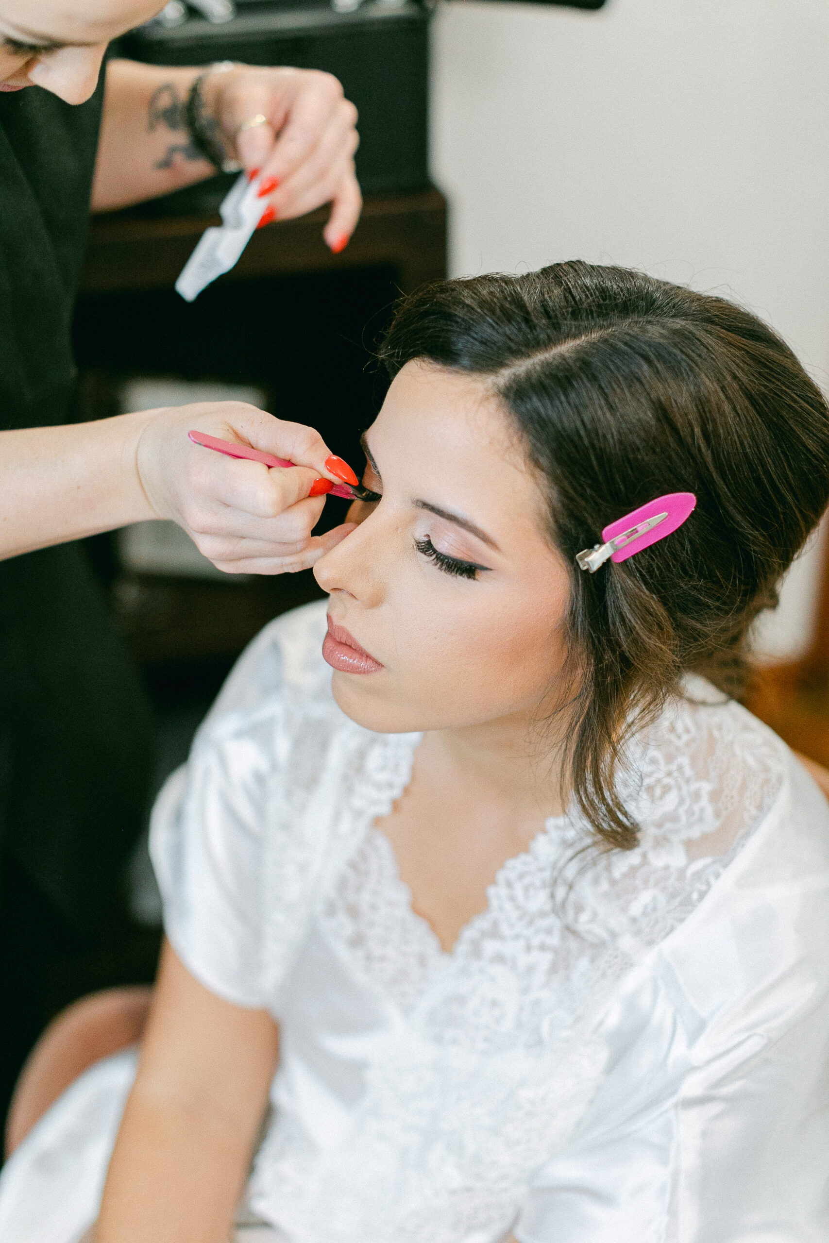 Kristy’s makeup artist applying color to the bride's eyelid as a finishing touch