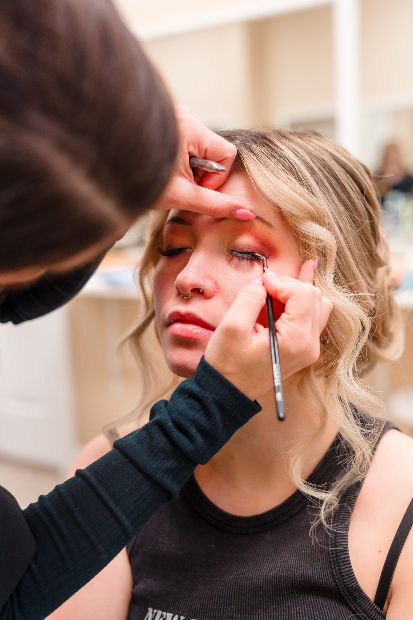 Professional makeup artist from Kristy's Artistry Design Team applying eyeliner to the bride in Orlando