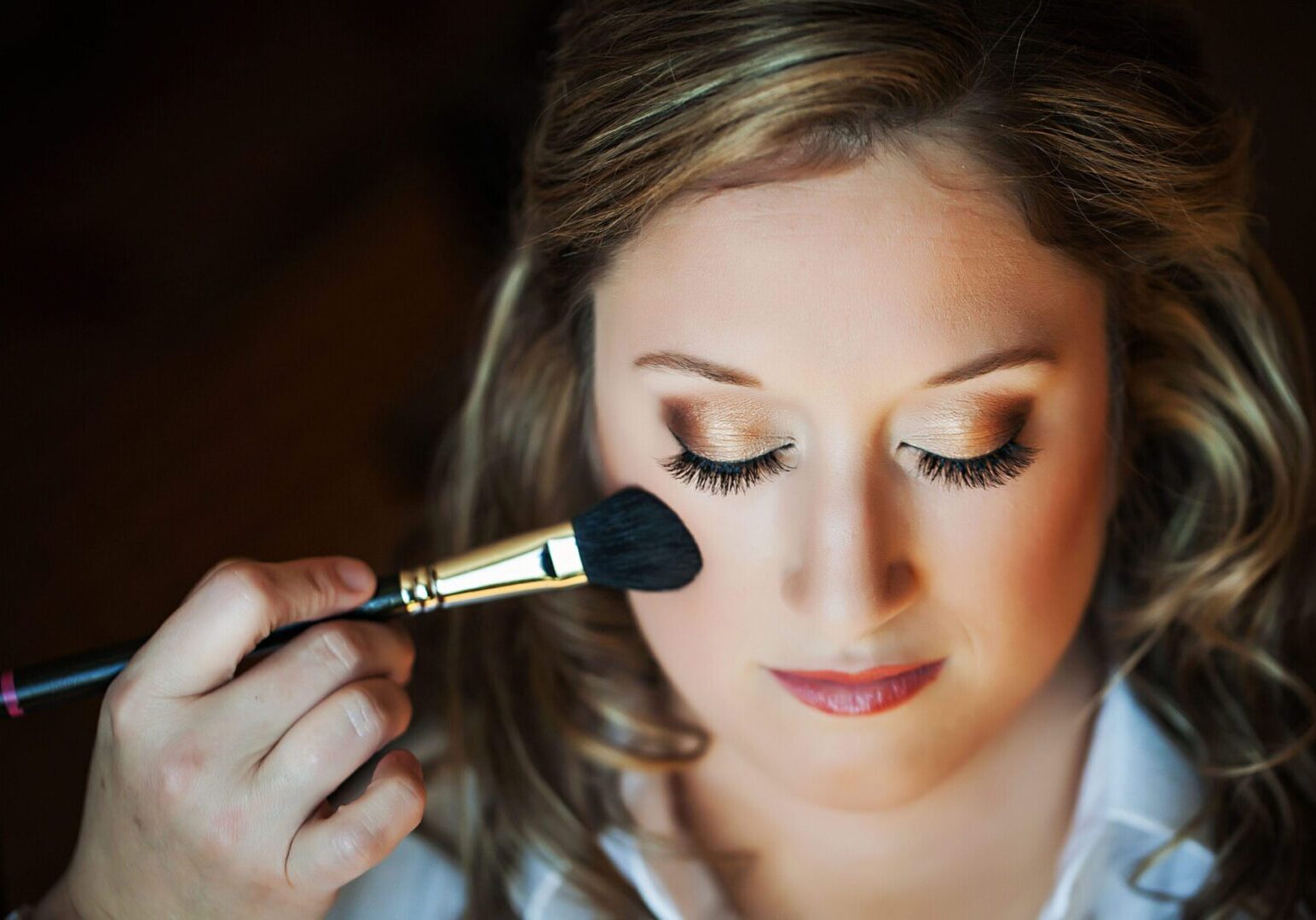 Woman applying makeup with a brush.