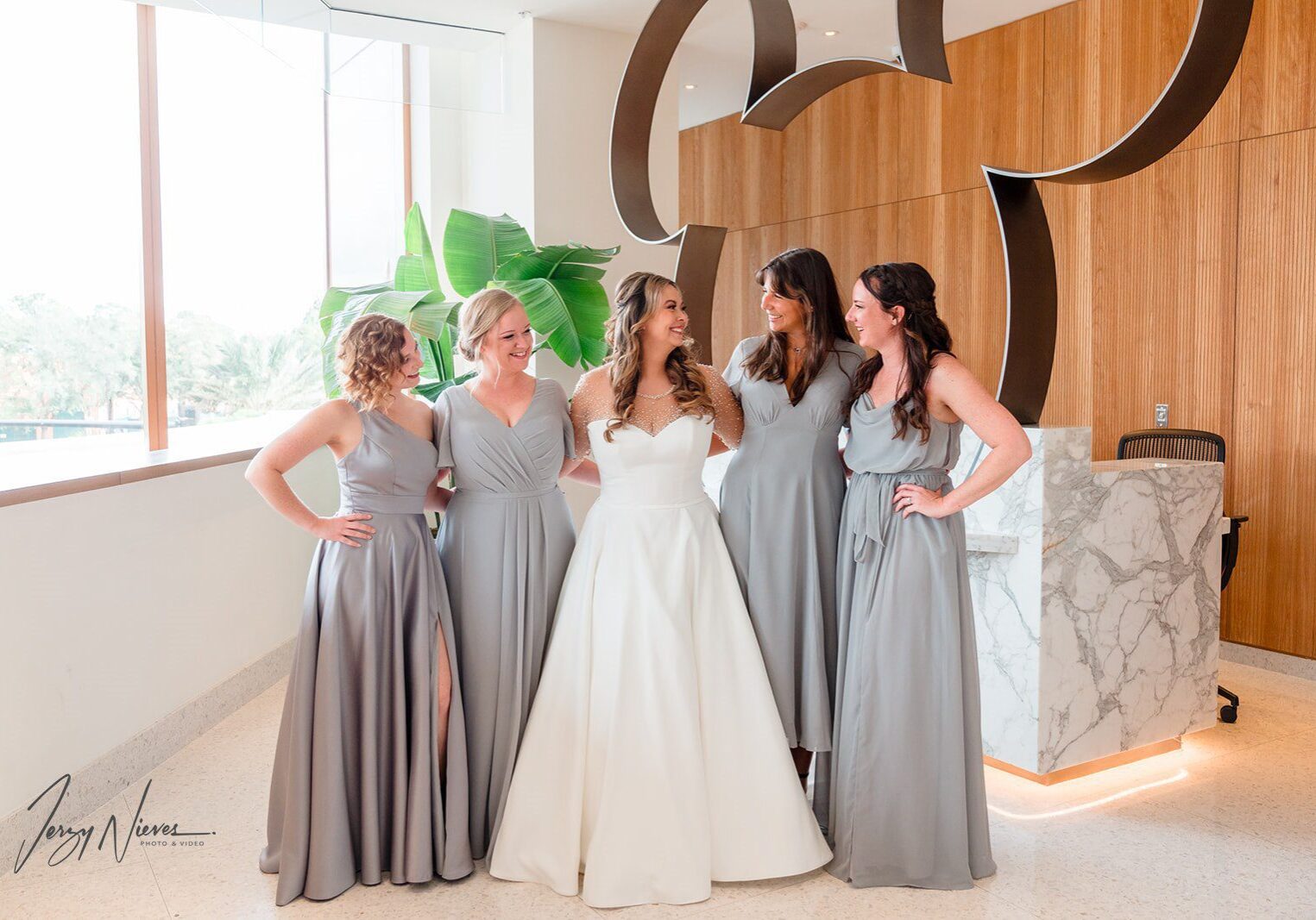 Bride with bridesmaids in elegant gray dresses.