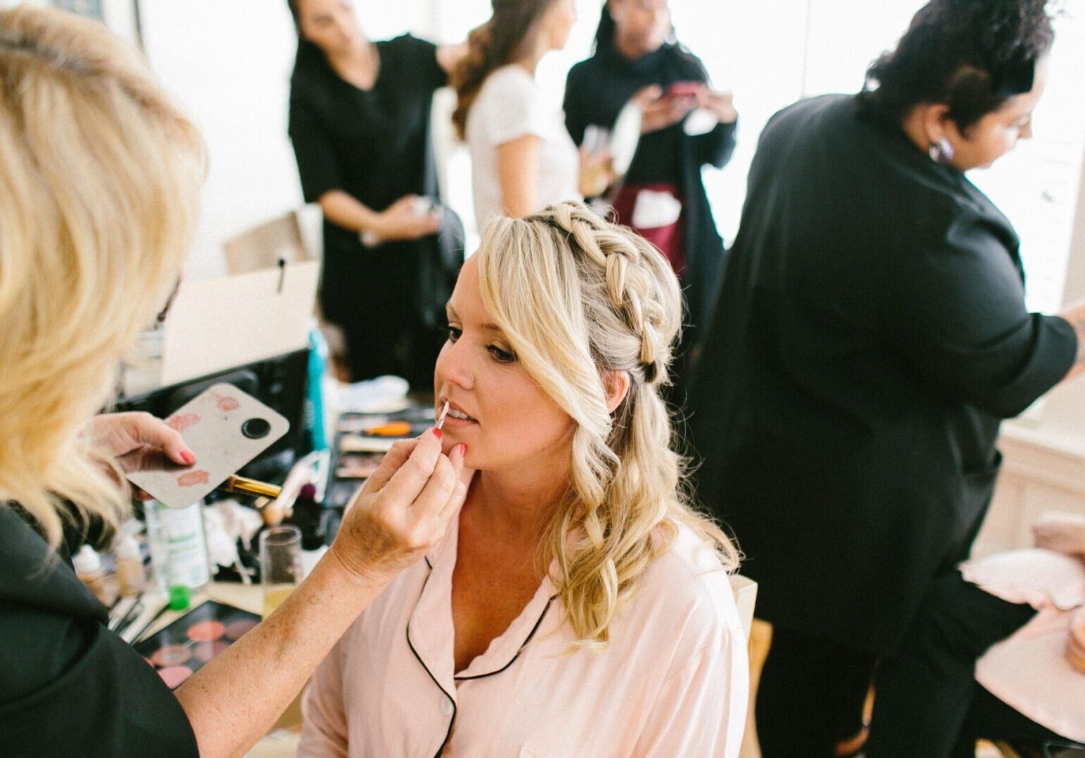 Woman getting makeup done in a salon.